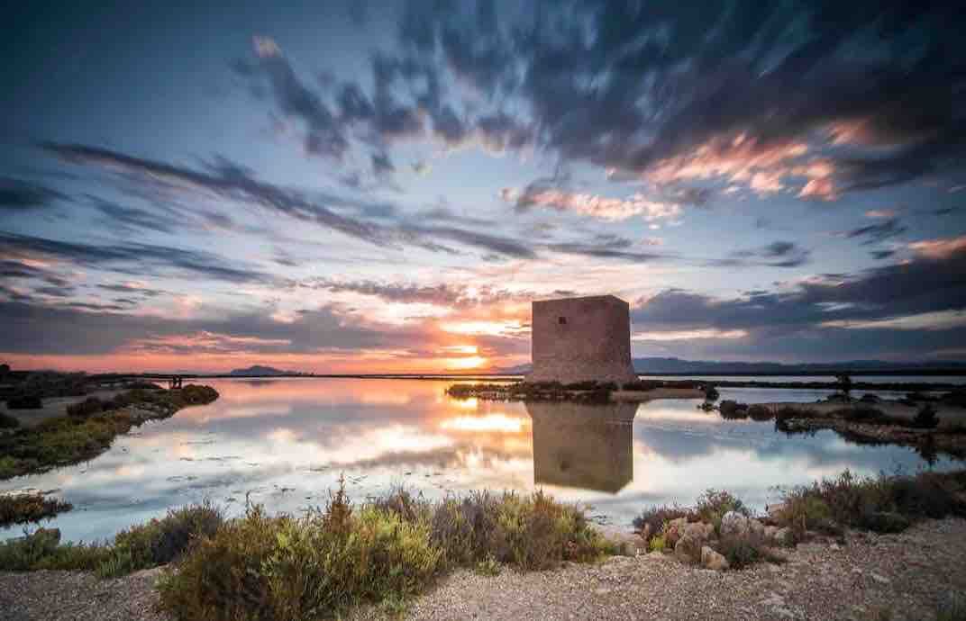 Tamarit tower reflected in the salt flats at sunset